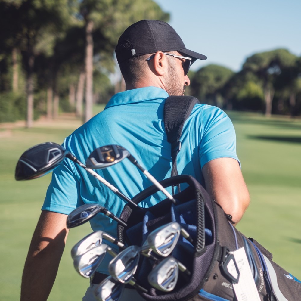 ゴルフコースをラウンドしている男性