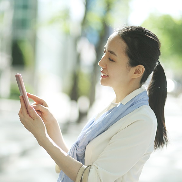 スマホ画面を見る人の画像